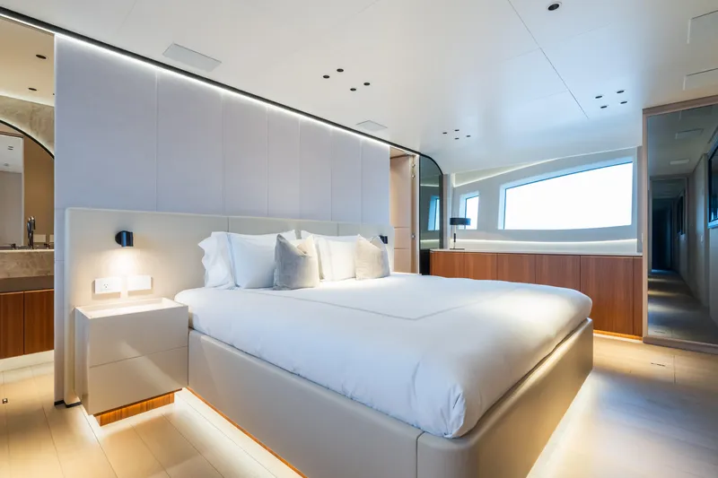 Yacht Photos Pics Luxurious bedroom interior of 2023 Mangusta 104 REV yacht with modern design and ambient lighting.