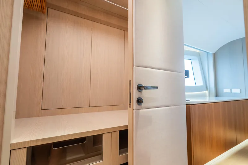  Yacht Photos Pics Interior of 2023 Mangusta 104 REV yacht, featuring sleek wooden cabinetry and modern design.