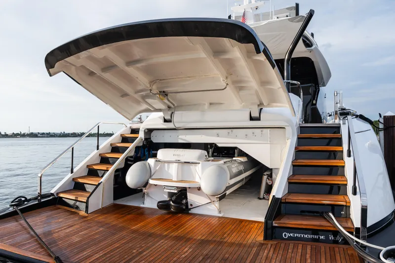  Yacht Photos Pics 2023 Mangusta 104 REV yacht with open garage, revealing a tender boat inside.