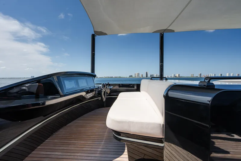  Yacht Photos Pics 2023 Mangusta 104 REV yacht deck with seating, overlooking a city skyline.