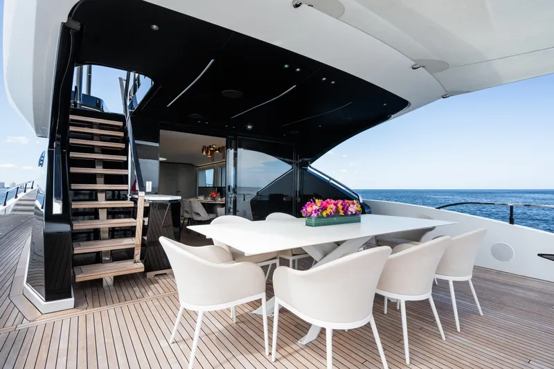  Yacht Photos Pics Luxury deck of 2023 Mangusta 104 REV yacht with dining area and ocean view.