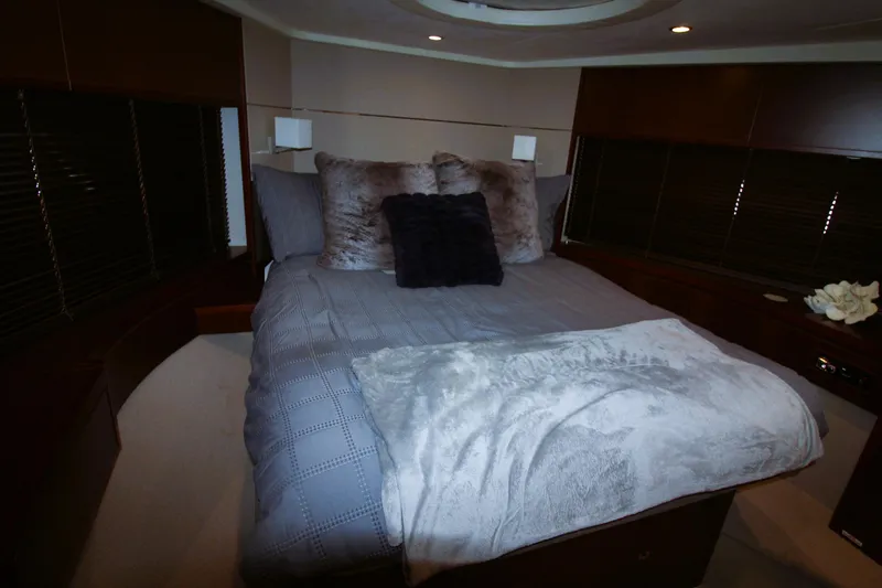  Yacht Photos Pics Luxurious bedroom interior of 2013 Princess V62 yacht with plush bedding and ambient lighting.
