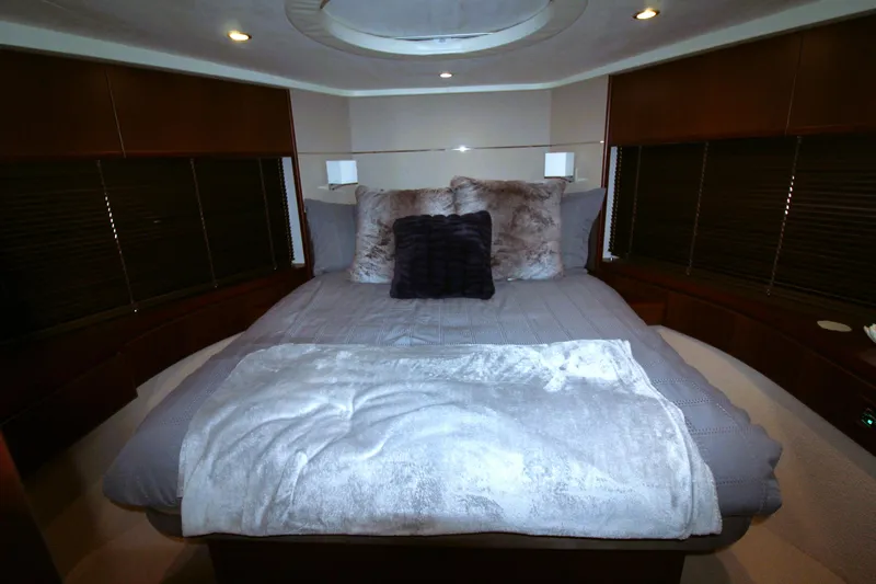  Yacht Photos Pics Luxurious bedroom interior of 2013 Princess V62 yacht with plush bedding and ambient lighting.