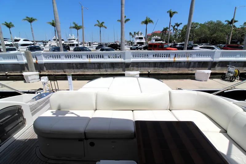  Yacht Photos Pics Luxurious 2013 Princess V62 yacht with elegant seating, docked near palm trees and parked cars.