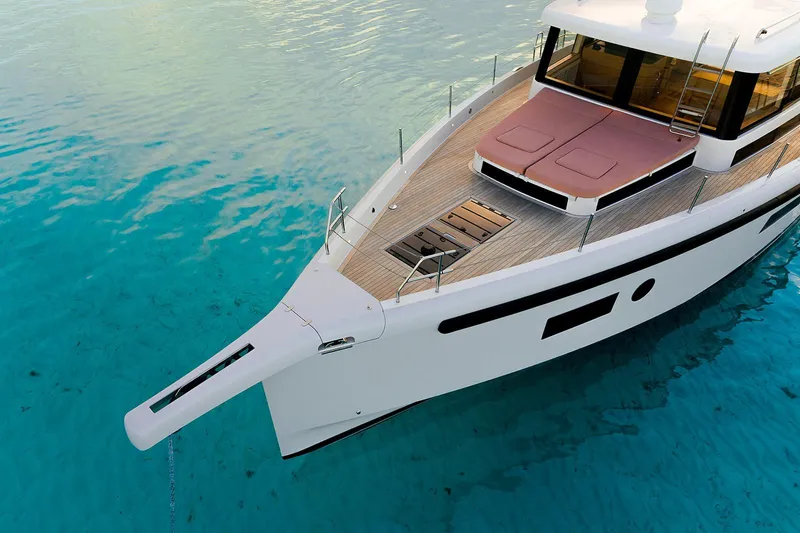  Yacht Photos Pics 2026 Omikron Yachts OT-60 on clear turquoise water, showcasing sleek design.