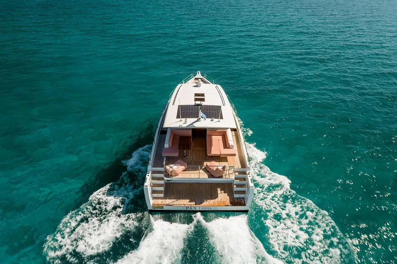  Yacht Photos Pics 2026 Omikron Yachts OT-60 cruising on clear turquoise waters, aerial view.