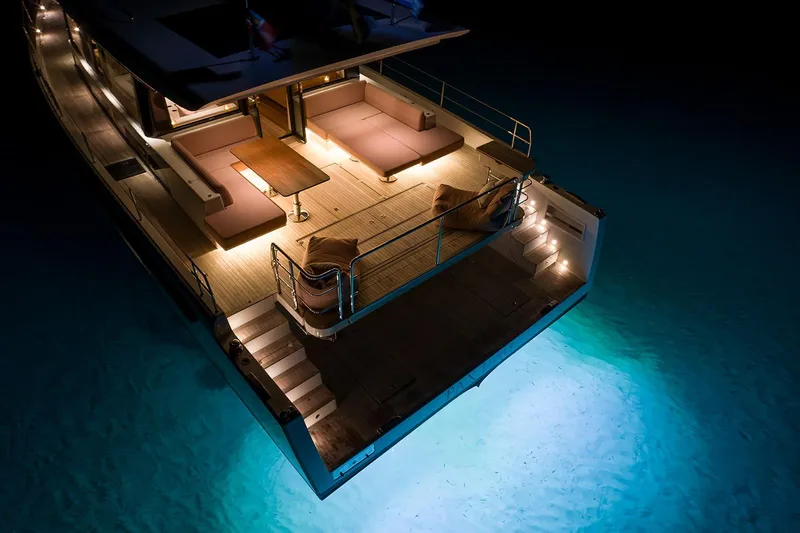  Yacht Photos Pics Luxurious Omikron Yachts OT-60, 2026 model, illuminated deck at night over serene water.