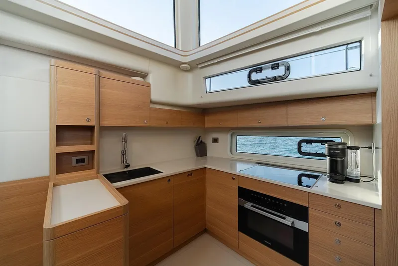  Yacht Photos Pics Modern kitchen interior of 2026 Omikron Yachts OT-60, featuring sleek wood cabinetry and ocean view.