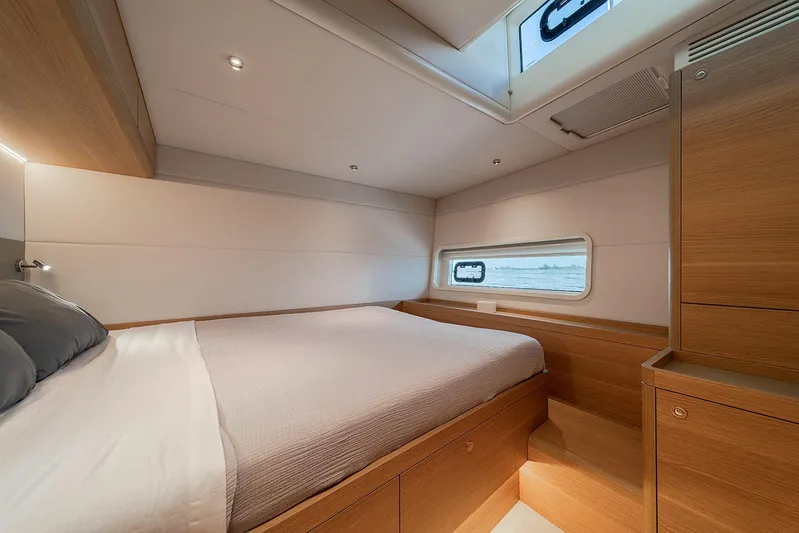  Yacht Photos Pics Luxurious cabin interior of 2026 Omikron Yachts OT-60, featuring modern wood finishes and cozy bedding.