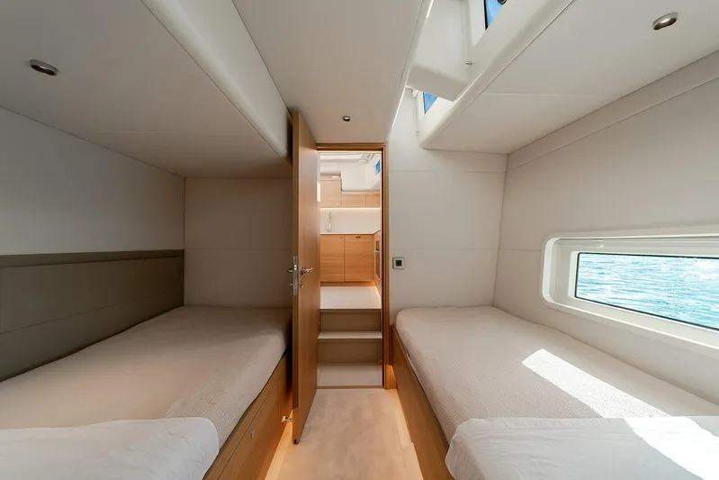  Yacht Photos Pics Interior of 2026 Omikron Yachts OT-60, featuring twin beds and a scenic window view.