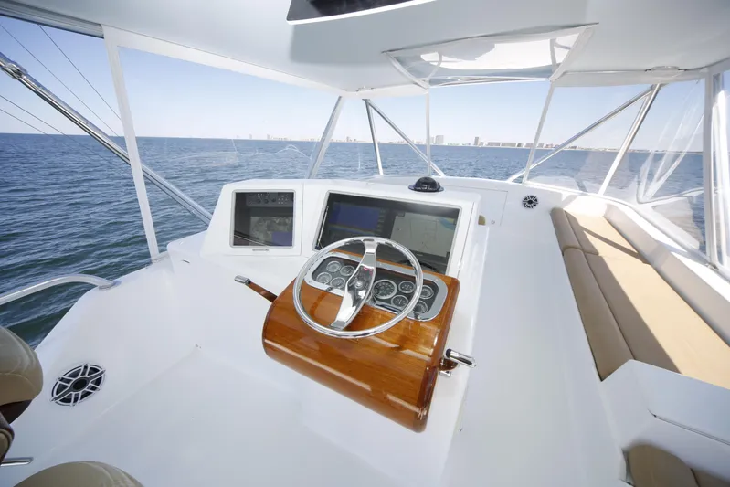 Pier Pressure Yacht Photos Pics Luxurious Jim Smith 65 Convertible yacht interior, featuring a sleek helm and panoramic ocean view.