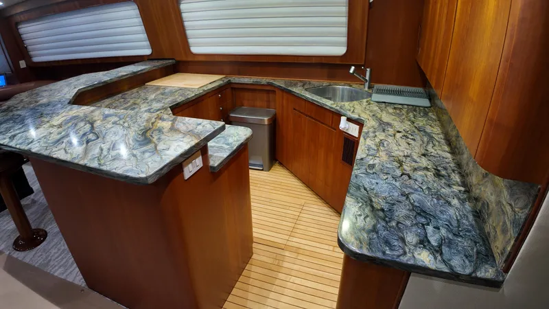 Pier Pressure Yacht Photos Pics Luxurious yacht kitchen with marble countertops, wooden cabinetry, and modern fixtures in a 2000 Jim Smith 65 Convertible.