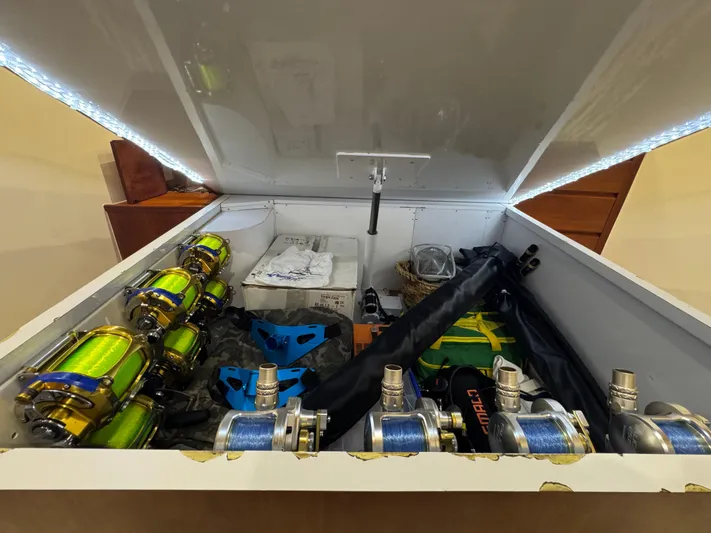 Pier Pressure Yacht Photos Pics Open storage compartment with fishing reels and gear, Jim Smith 65 Convertible, 2000 model.