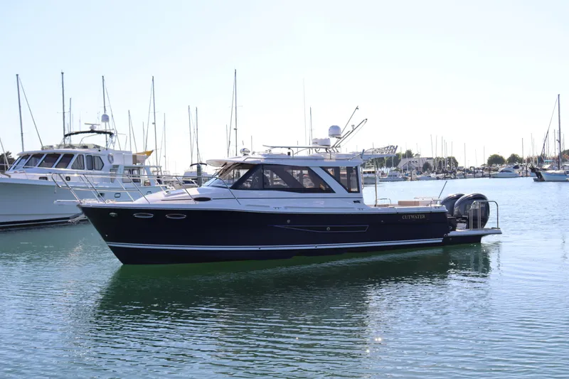 Silver Eagle Yacht Photos Pics 2024 Cutwater 32 Coupe NW Edition boat on calm water, docked in a marina.
