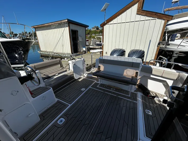 Silver Eagle Yacht Photos Pics 2024 Cutwater 32 Coupe NW Edition boat interior with seating and steering wheel at a marina.