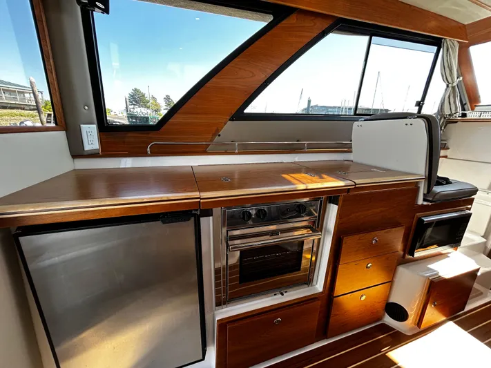 Silver Eagle Yacht Photos Pics 2024 Cutwater 32 Coupe NW Edition interior kitchen with wood finish and modern appliances.