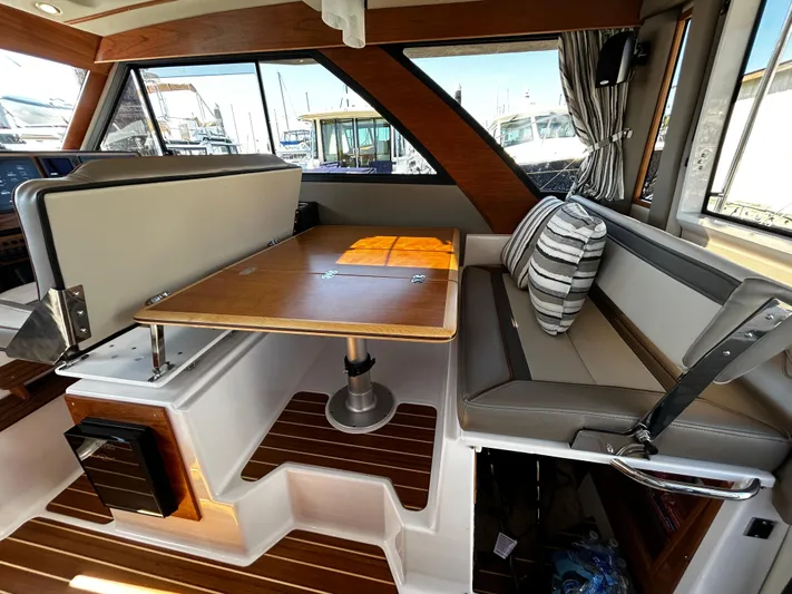 Silver Eagle Yacht Photos Pics 2024 Cutwater 32 Coupe NW Edition interior with dining area and striped cushion.