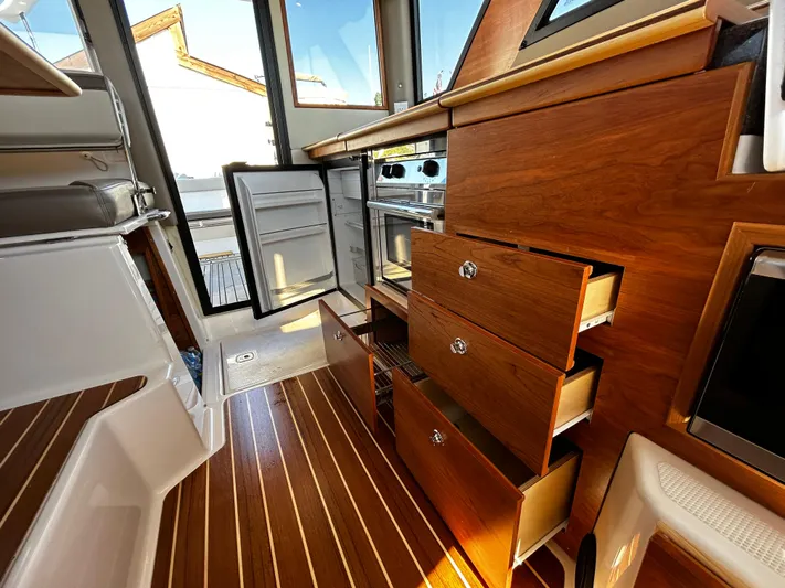 Silver Eagle Yacht Photos Pics 2024 Cutwater 32 Coupe NW Edition interior with open drawers and fridge, showcasing wood finish.