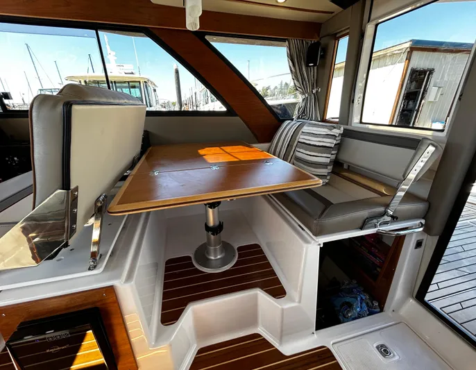 Silver Eagle Yacht Photos Pics 2024 Cutwater 32 Coupe NW Edition interior with dining area and striped cushions.
