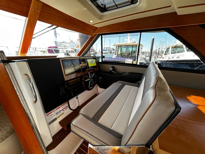 Silver Eagle Yacht Photos Pics 2024 Cutwater 32 Coupe NW Edition interior with helm, seating, and marina view.