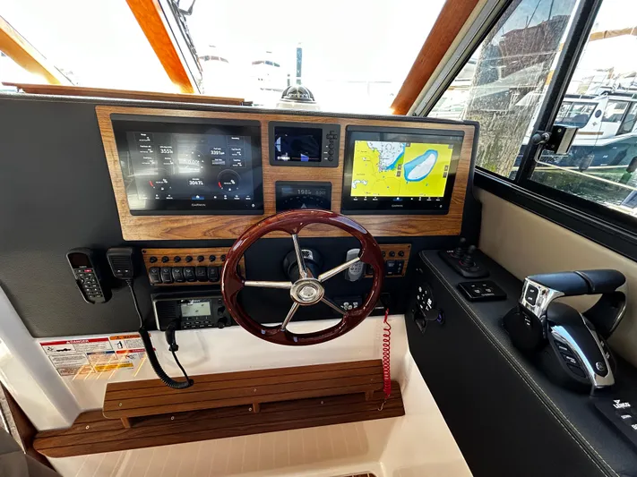 Silver Eagle Yacht Photos Pics 2024 Cutwater 32 Coupe NW Edition helm with navigation screens and wooden steering wheel.