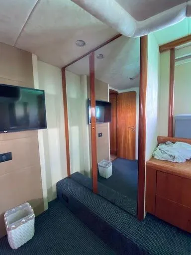 Venko Yacht Photos Pics 2006 Sunseeker Manhattan 50 yacht interior with TV, mirrors, and wooden cabinetry.