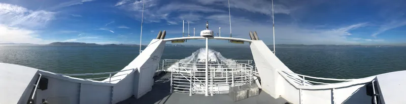 Billie J Yacht Photos Pics High-speed passenger ferry cruising on open water under a clear blue sky.