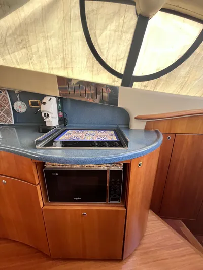  Yacht Photos Pics 2004 Azimut 55 yacht kitchen with microwave, countertop, and wooden cabinetry.