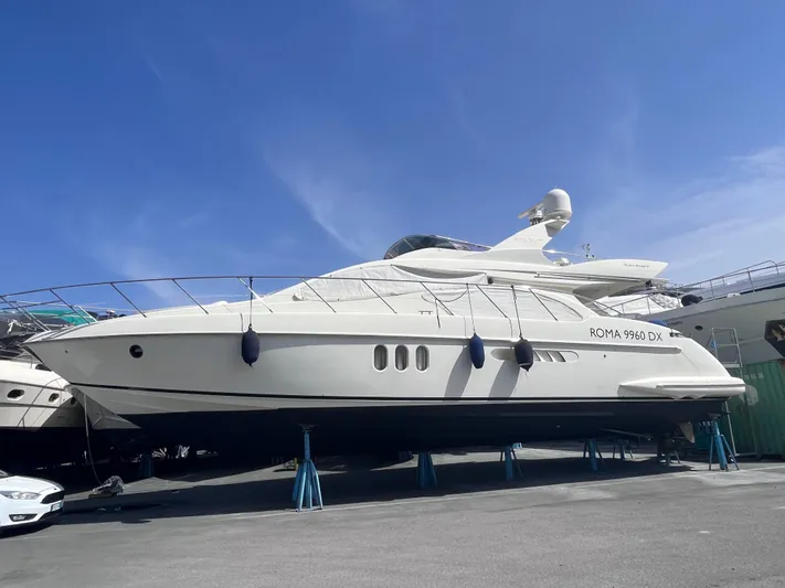  Yacht Photos Pics Azimut 55 yacht from 2004 on stands, displayed outdoors under a clear blue sky.