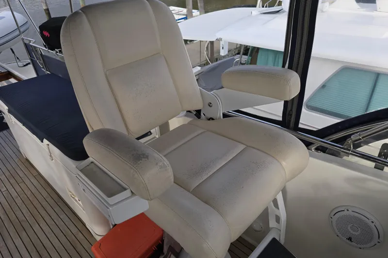 Halcyon Yacht Photos Pics Captain's chair on 2005 Grand Banks 46 Europa yacht, featuring beige upholstery and armrests.
