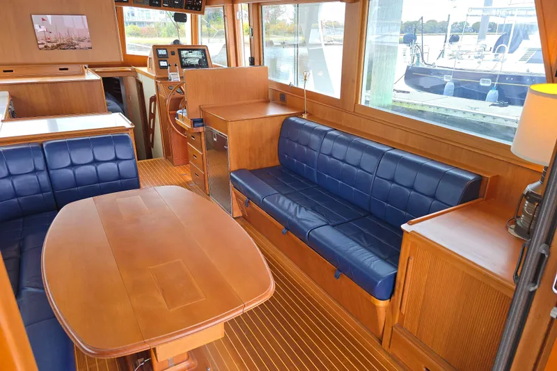 Halcyon Yacht Photos Pics Interior of 2005 Grand Banks 46 Europa yacht with blue seating and wooden finishes.