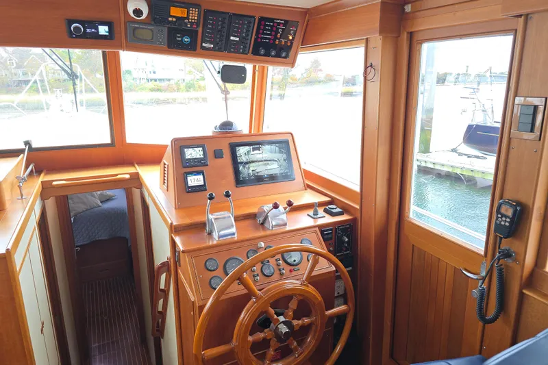 Halcyon Yacht Photos Pics Helm of 2005 Grand Banks 46 Europa yacht with wooden steering wheel and navigation instruments.