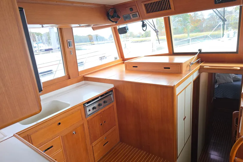 Halcyon Yacht Photos Pics Interior of 2005 Grand Banks 46 Europa yacht, featuring wooden cabinetry and large windows.