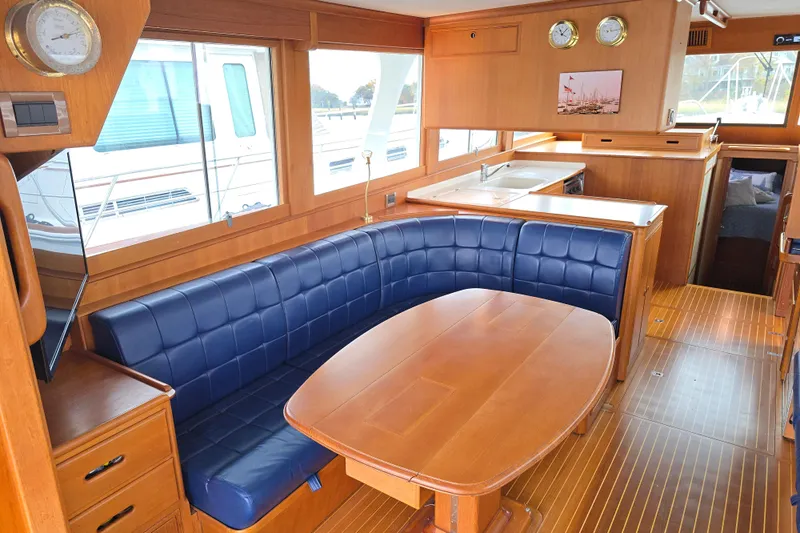 Halcyon Yacht Photos Pics Luxurious 2005 Grand Banks 46 Europa yacht interior with blue leather seating and wooden finishes.