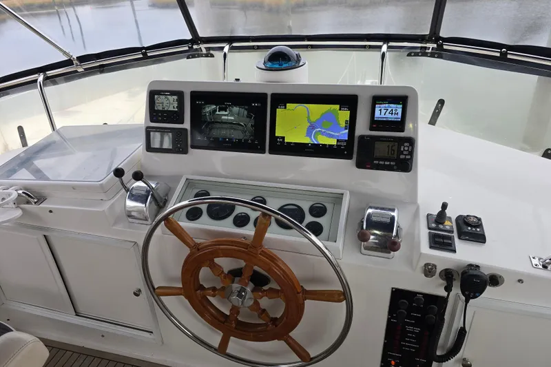 Halcyon Yacht Photos Pics Helm of 2005 Grand Banks 46 Europa with navigation screens and wooden steering wheel.