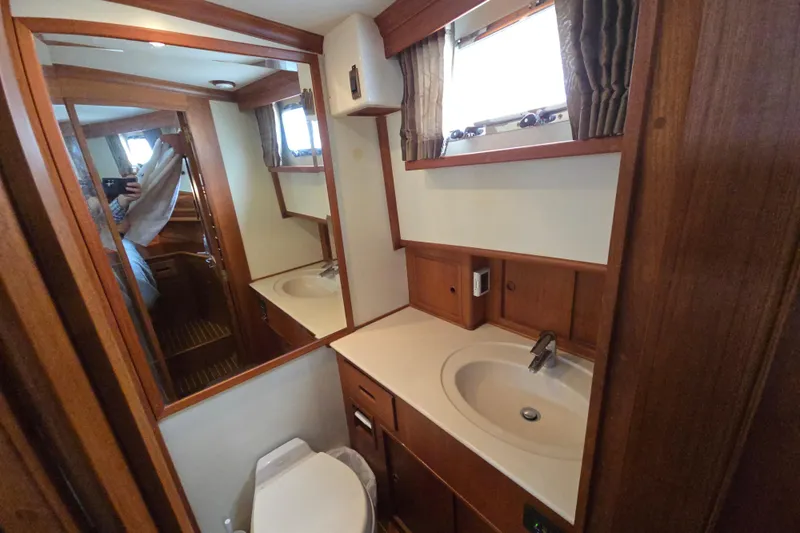 Halcyon Yacht Photos Pics Luxurious 2005 Grand Banks 46 Europa yacht bathroom with wood accents and modern fixtures.