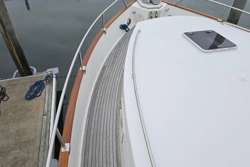 Halcyon Yacht Photos Pics 2005 Grand Banks 46 Europa yacht deck with wooden railings and docked at marina.