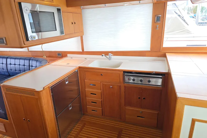 Halcyon Yacht Photos Pics Galley of 2005 Grand Banks 46 Europa yacht with modern appliances and wood cabinetry.