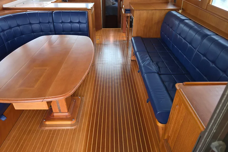 Halcyon Yacht Photos Pics Interior of 2005 Grand Banks 46 Europa yacht with wooden flooring and blue seating.