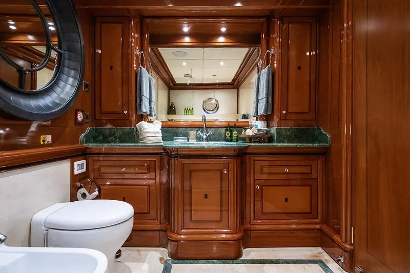 Yazz Yacht Photos Pics Luxurious bathroom on 2007 Aegean Yacht Schooner with wooden cabinetry and green marble countertops.