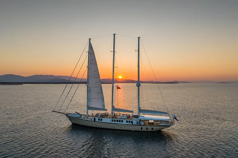 Yazz Yacht Photos Pics Aegean Yacht Schooner 2007 sailing at sunset on calm waters.