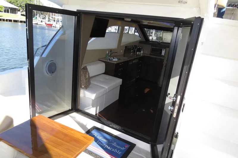  Yacht Photos Pics 2016 Carver C40 Command Bridge interior with open glass doors, white seating, and kitchenette.