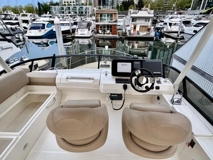  Yacht Photos Pics 2016 Carver C40 Command Bridge helm with dual seats, overlooking marina with multiple boats.