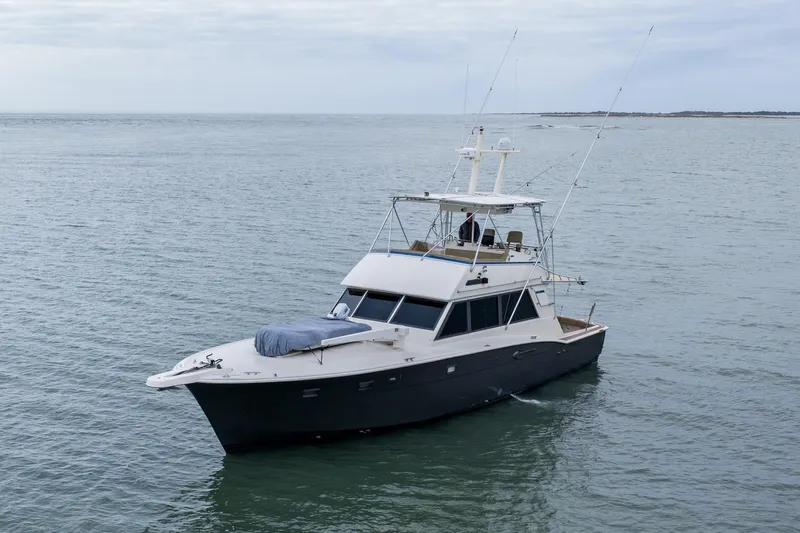  Yacht Photos Pics 1984 Hatteras 52 Convertible yacht cruising on calm ocean waters.