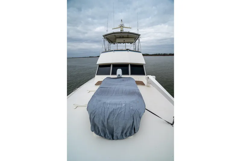  Yacht Photos Pics 1984 Hatteras 52 Convertible yacht on water, overcast sky, covered equipment on deck.