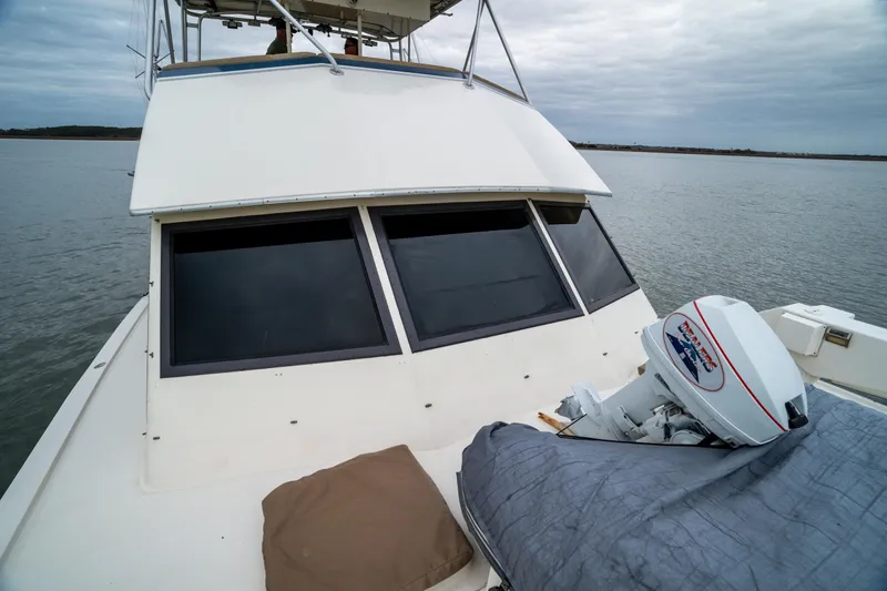  Yacht Photos Pics 1984 Hatteras 52 Convertible yacht on calm water, featuring a covered outboard motor.