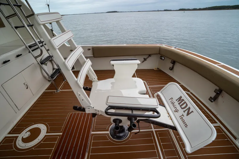  Yacht Photos Pics 1984 Hatteras 52 Convertible fishing deck with chair, overlooking calm waters.