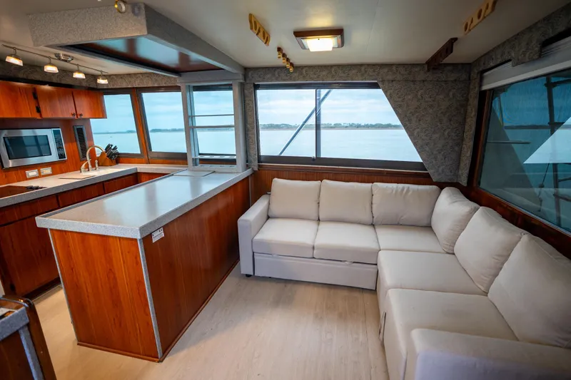  Yacht Photos Pics Luxurious interior of 1984 Hatteras 52 Convertible yacht with modern kitchen and cozy seating.