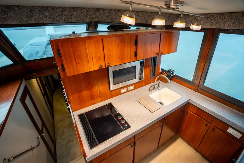  Yacht Photos Pics 1984 Hatteras 52 Convertible yacht kitchen with wood cabinets, stove, and sink.