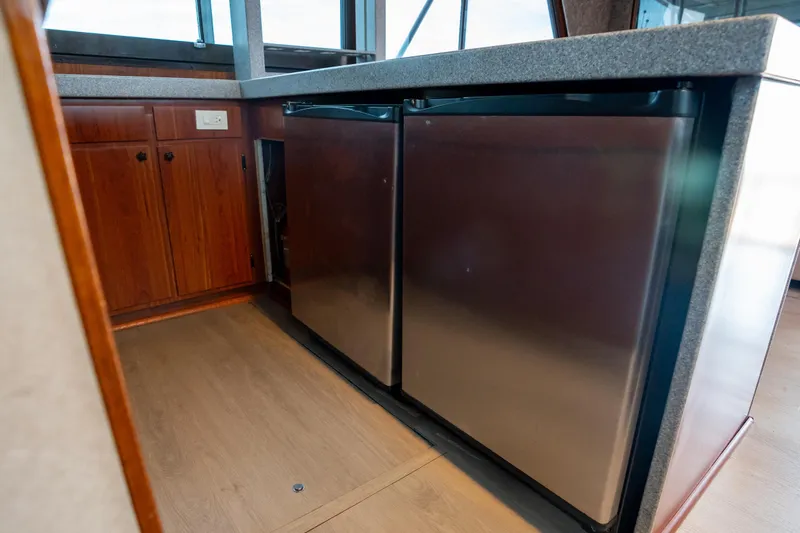  Yacht Photos Pics 1984 Hatteras 52 Convertible yacht interior with stainless steel appliances and wooden cabinetry.